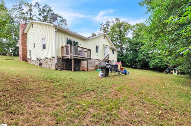 back of house with a wooden deck and a lawn