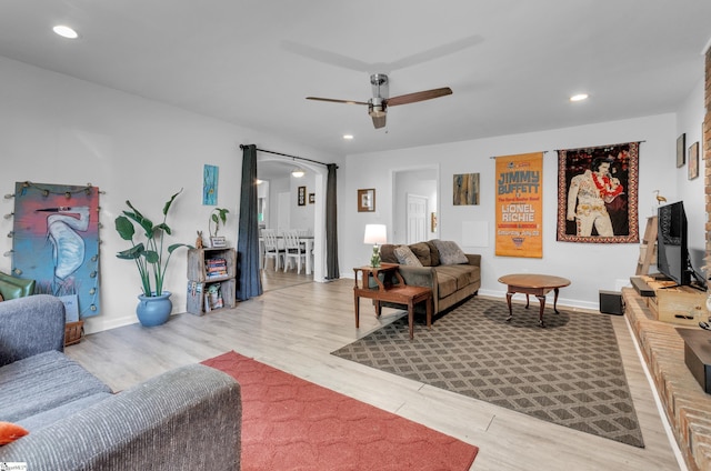 living room with ceiling fan and light wood-type flooring