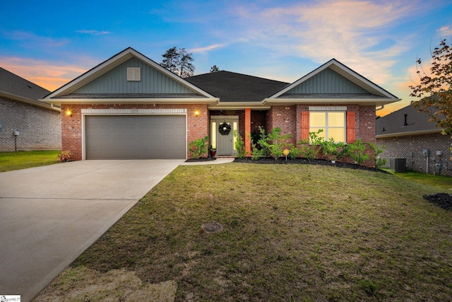 view of front of property featuring a lawn, cooling unit, and a garage