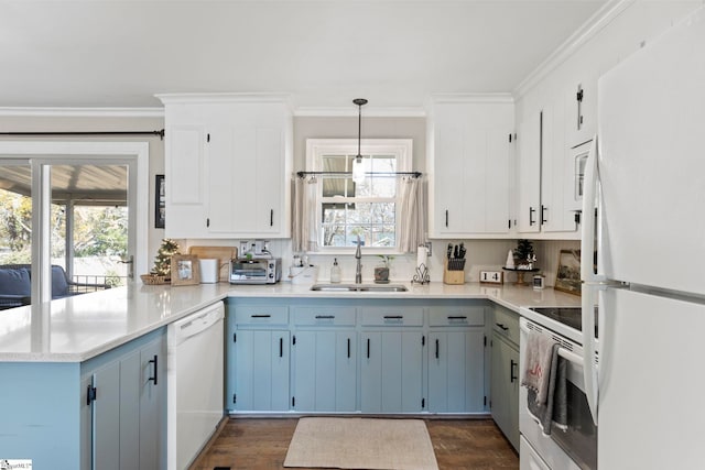 kitchen featuring a healthy amount of sunlight, sink, hanging light fixtures, and white appliances