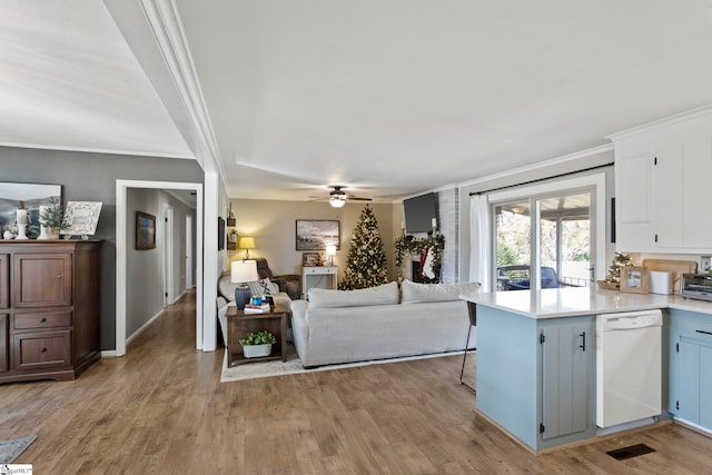 living room featuring ceiling fan, crown molding, and light hardwood / wood-style floors