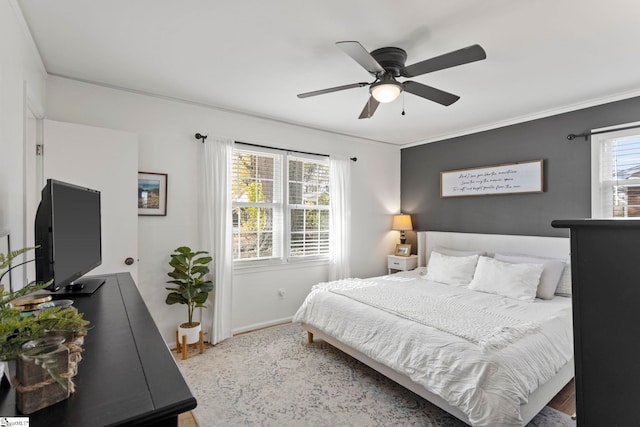 bedroom featuring ceiling fan, crown molding, and multiple windows