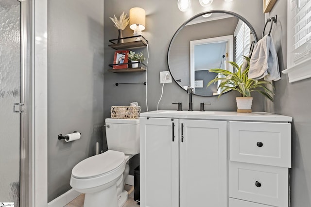 bathroom featuring tile patterned floors, vanity, toilet, and a shower with door