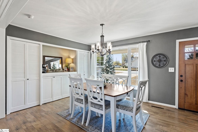 dining area featuring a healthy amount of sunlight, light hardwood / wood-style floors, and a notable chandelier