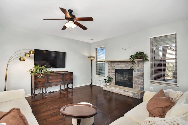 living room featuring a fireplace, ceiling fan, and dark wood-type flooring