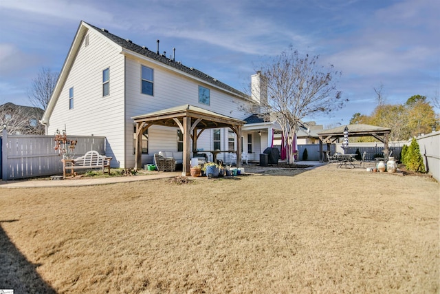 back of property featuring a gazebo, an outdoor living space, and a patio area