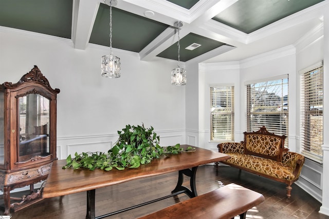 living area with dark hardwood / wood-style flooring, beamed ceiling, a chandelier, and ornamental molding