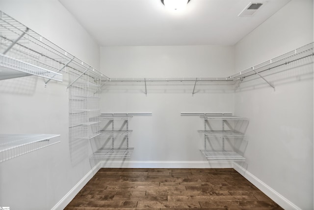 walk in closet with dark hardwood / wood-style flooring