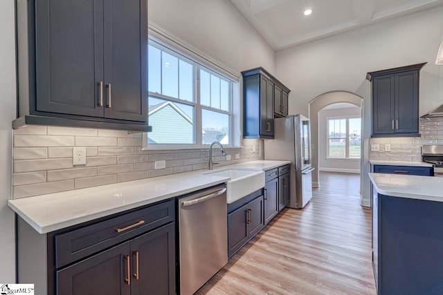 kitchen with decorative backsplash, light hardwood / wood-style flooring, a healthy amount of sunlight, and appliances with stainless steel finishes