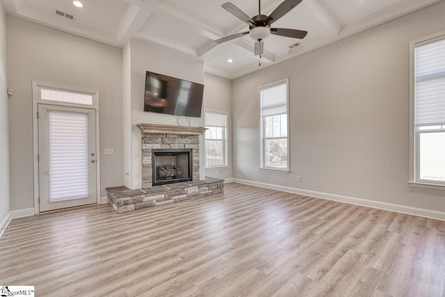 unfurnished living room with plenty of natural light, coffered ceiling, and light wood-type flooring