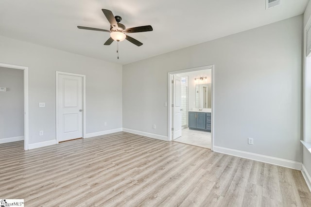 unfurnished bedroom with light wood-type flooring, ceiling fan, and connected bathroom