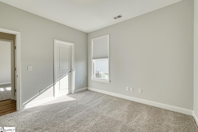 unfurnished room featuring light colored carpet