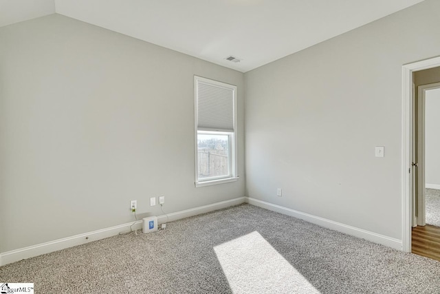 unfurnished room with carpet flooring and lofted ceiling