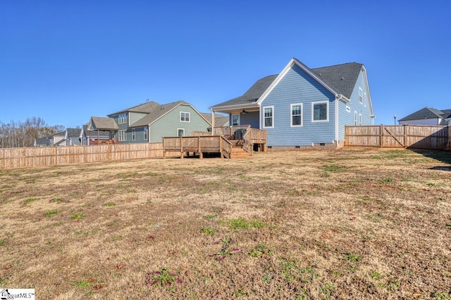 rear view of property with a yard and a deck