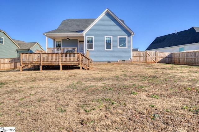 rear view of property featuring a deck, ceiling fan, and a lawn