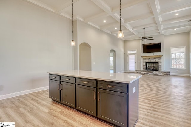 kitchen featuring decorative light fixtures, a kitchen island, and light hardwood / wood-style flooring