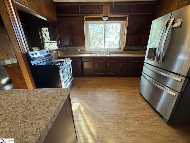 kitchen with light hardwood / wood-style floors, dark brown cabinetry, and stainless steel appliances