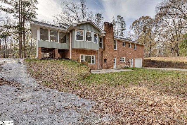 rear view of property featuring a garage and a sunroom