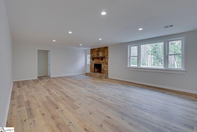 unfurnished living room with a fireplace and light wood-type flooring