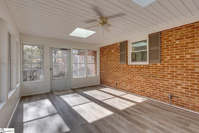 unfurnished sunroom with a skylight, a wealth of natural light, and ceiling fan