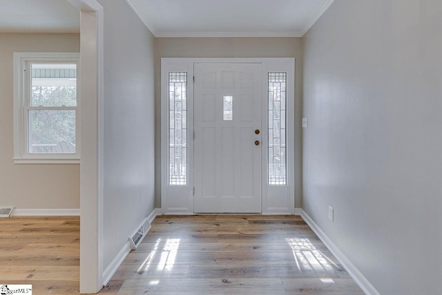 foyer entrance featuring crown molding and light wood-type flooring