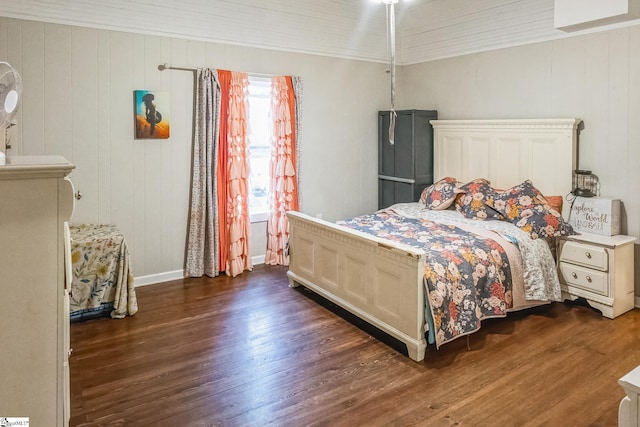 bedroom with dark hardwood / wood-style flooring, wooden walls, and crown molding