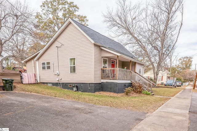 view of side of property with a yard and covered porch