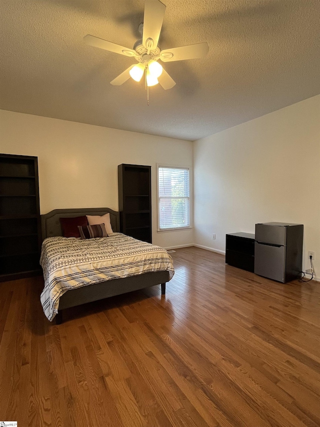 bedroom with ceiling fan, a textured ceiling, and hardwood / wood-style flooring