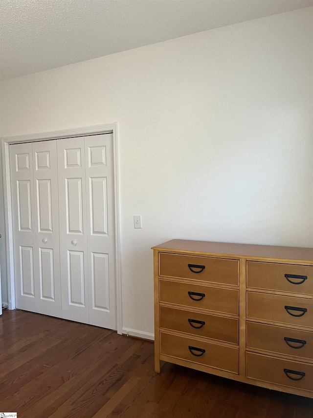 unfurnished bedroom featuring a closet and dark hardwood / wood-style floors