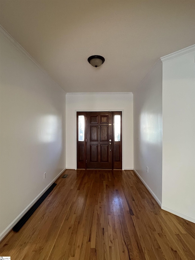 foyer entrance with dark hardwood / wood-style flooring and ornamental molding