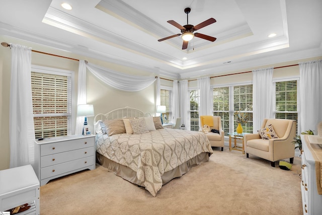 bedroom featuring a raised ceiling, ceiling fan, light colored carpet, and ornamental molding