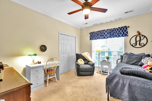 bedroom featuring ceiling fan, light colored carpet, ornamental molding, and a closet