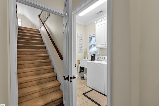 staircase with washer / clothes dryer, crown molding, and tile patterned flooring