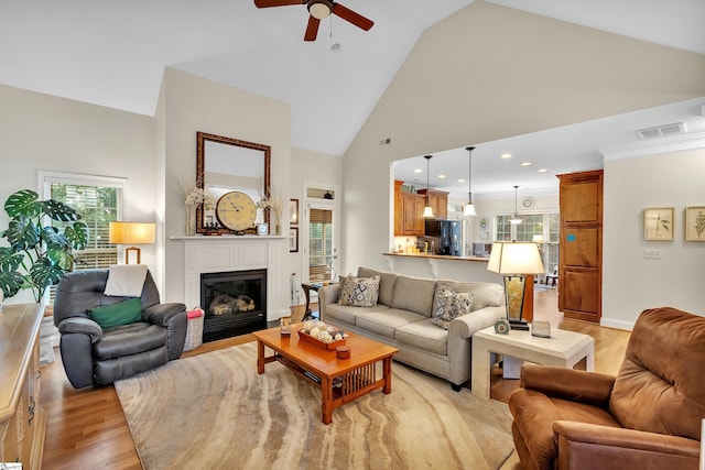 living room featuring ceiling fan, light wood-type flooring, and high vaulted ceiling