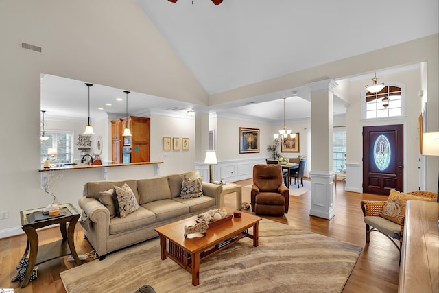 living room with high vaulted ceiling, light wood-type flooring, and a wealth of natural light