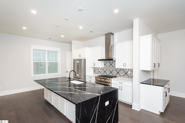 kitchen featuring a large island with sink, dark hardwood / wood-style floors, high end appliances, and wall chimney range hood