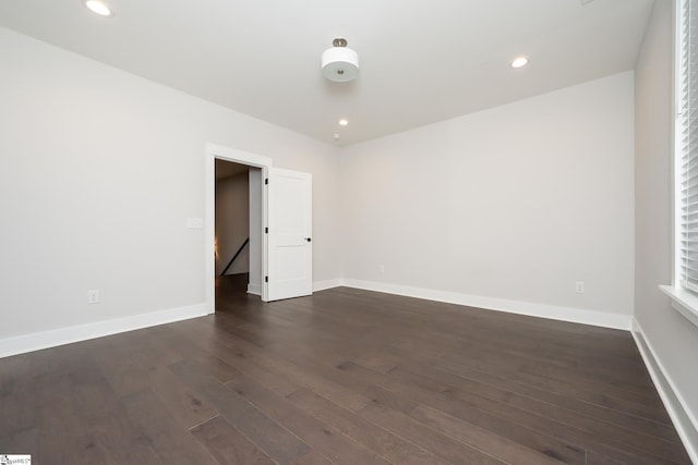 unfurnished room with dark hardwood / wood-style flooring