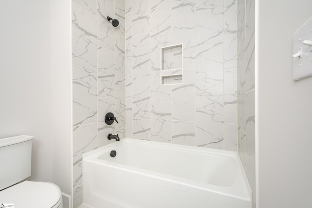 bathroom featuring tiled shower / bath combo and toilet