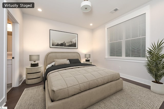 bedroom with dark hardwood / wood-style flooring and connected bathroom