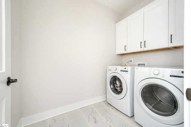 clothes washing area with cabinets and washing machine and clothes dryer