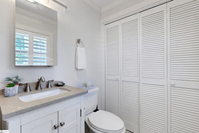 bathroom with crown molding, vanity, and toilet