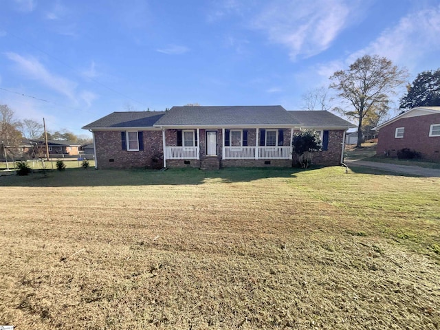 ranch-style home featuring covered porch and a front yard