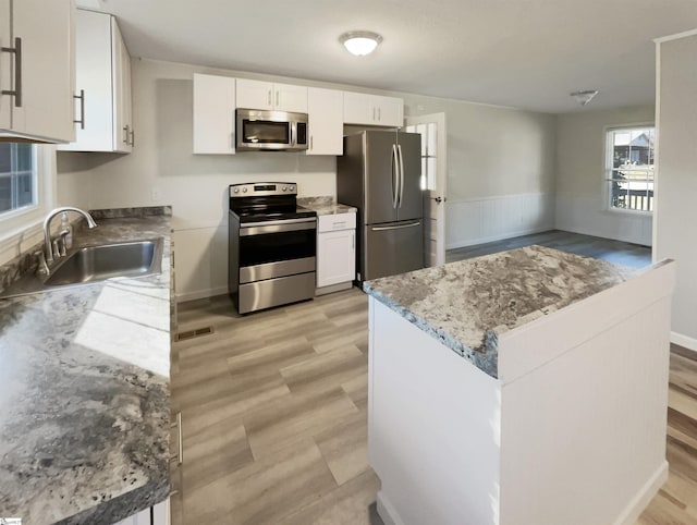 kitchen featuring light wood-type flooring, white cabinetry, sink, and appliances with stainless steel finishes