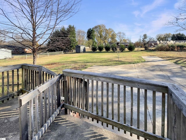 deck featuring a lawn and a storage unit