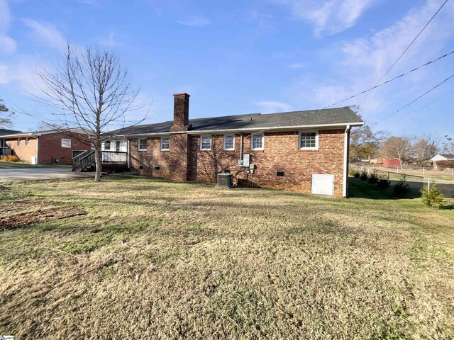 back of house featuring a yard, central AC, and a deck