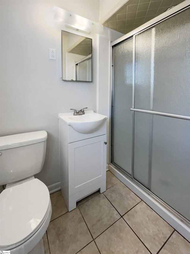 bathroom featuring tile patterned flooring, vanity, toilet, and a shower with shower door