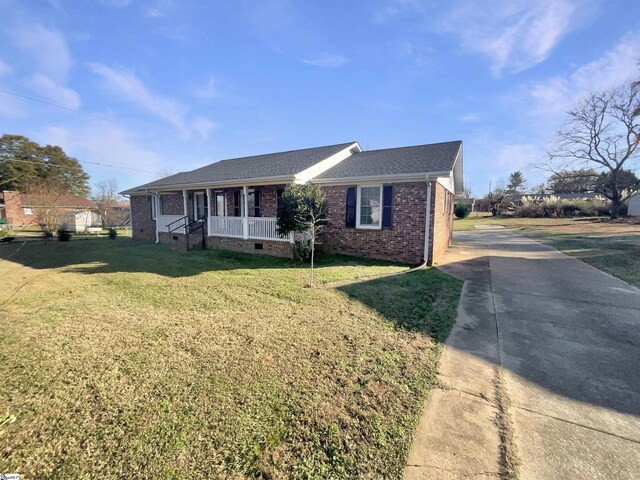 ranch-style home with covered porch and a front yard