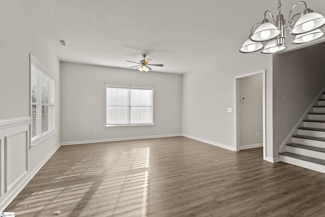 unfurnished living room with ceiling fan with notable chandelier and dark hardwood / wood-style floors