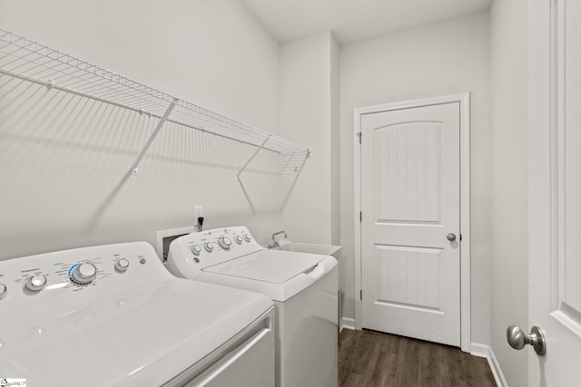 laundry area featuring washer and clothes dryer, dark hardwood / wood-style floors, and sink