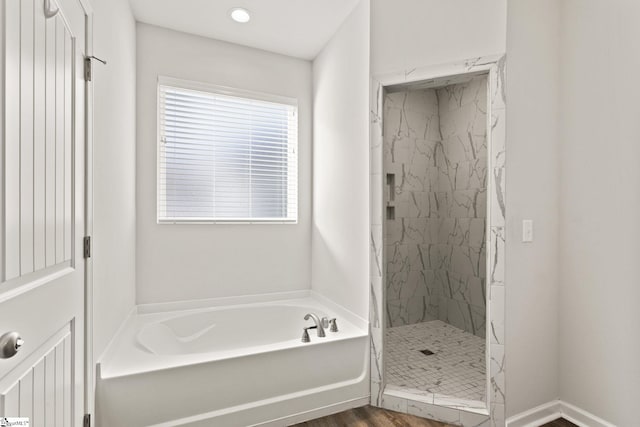 bathroom featuring shower with separate bathtub and hardwood / wood-style flooring